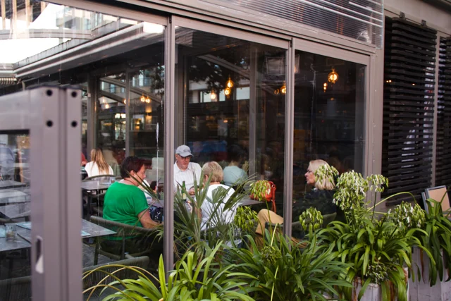 Het overdekte terras van het Zeezotje met gasten en planten